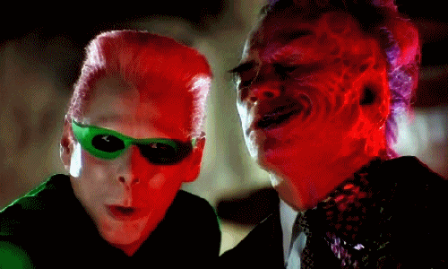 Extrait de Batman Forever où Double Faces (Jones) parle à l'oreille de l'homme mystère (Jim Carrey)